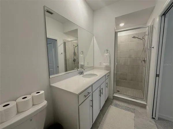 a bathroom with a sink a mirror and a shower