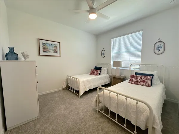 a bedroom with two beds and a chandelier