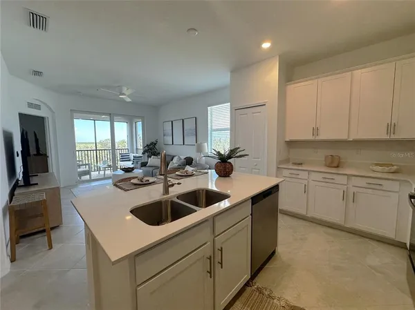 a kitchen with sink a microwave and cabinets