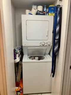 a kitchen with stainless steel appliances a refrigerator a sink and white cabinets