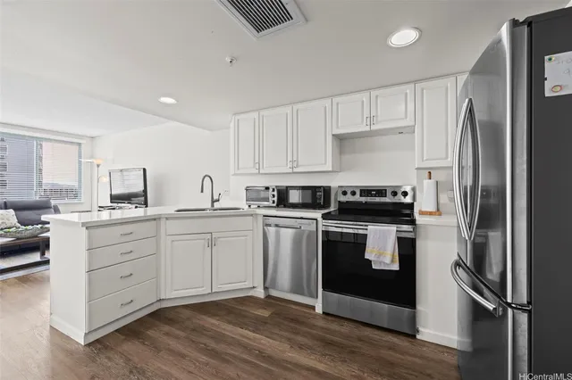 a kitchen with a refrigerator a stove top oven and cabinets