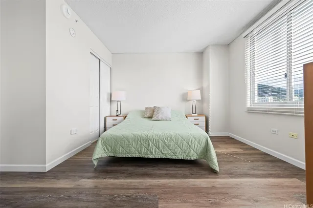 a bedroom with a bed and wooden floor