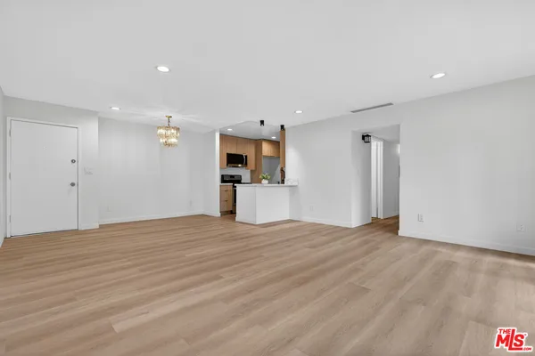 a view of empty room with wooden floor and window
