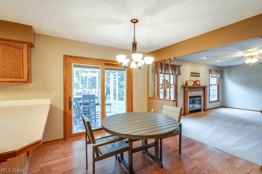 826 Stewart Road Kent, OH 44240 - Photo 21 of 43 Dining room with a textured ceiling, light hardwood / wood-style flooring, and ceiling fan with notable chandelier