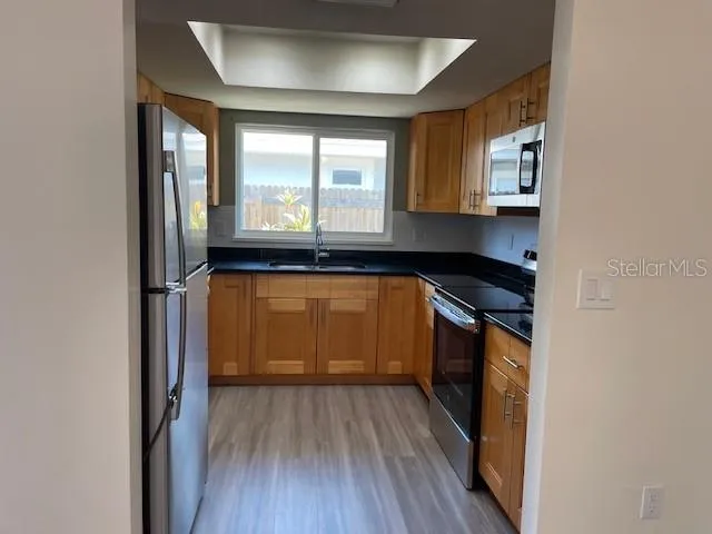 a kitchen with granite countertop white cabinets and wooden floor