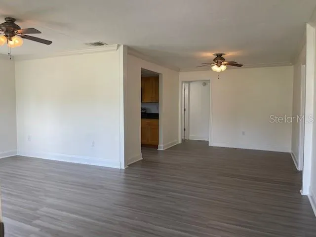 a view of empty room with wooden floor