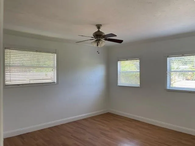 a view of a workspace with wooden floor and a window