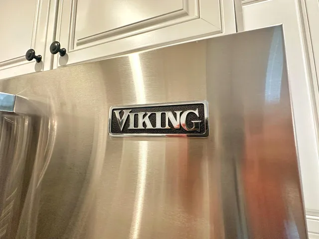 a kitchen with white cabinets and a wooden floor