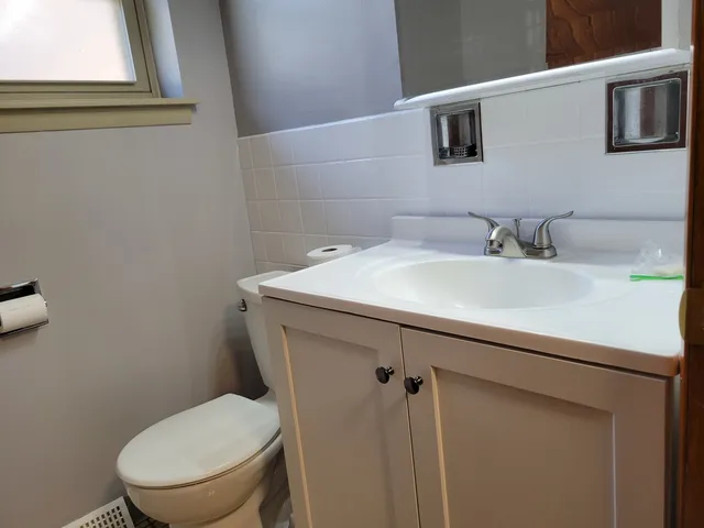 a bathroom with a sink mirror vanity and toilet