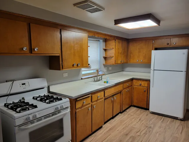 a kitchen with stainless steel appliances a stove a sink and a refrigerator