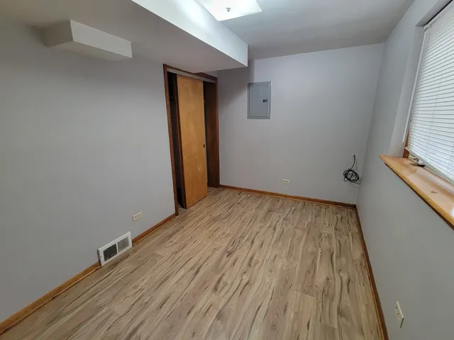 a view of a room with wooden floor and a window