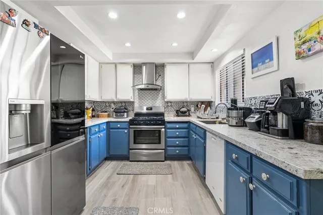 a kitchen with granite countertop a refrigerator stove top oven and sink