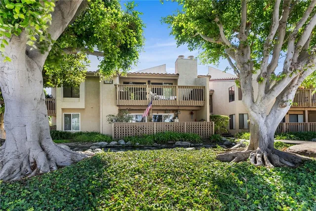 a front view of a house with garden and trees