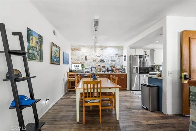 a view of a dining room with furniture a rug and wooden floor