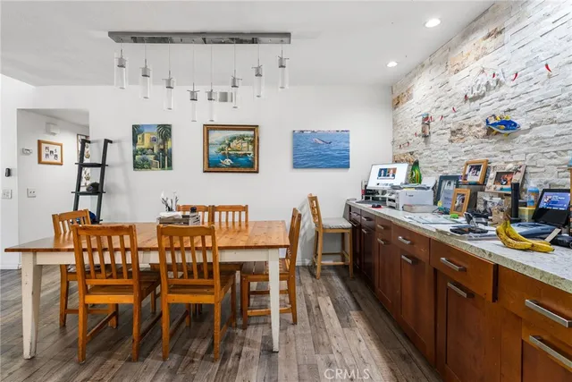 a dining room with stainless steel appliances a dining table and chairs with wooden floor