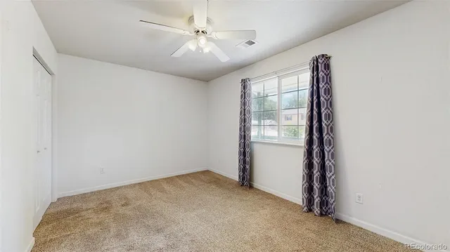 an empty room with a ceiling fan and a ceiling fan