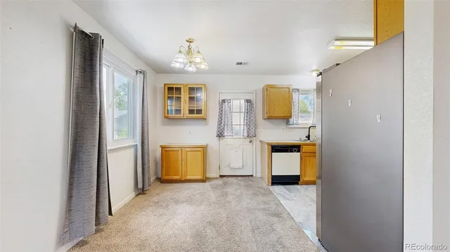 a view of a kitchen with a sink and a refrigerator