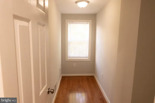 a view of a room with wooden floor and a window