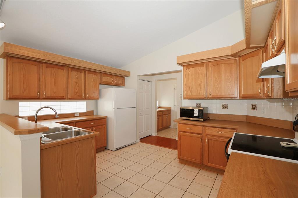6318 Southwest 117th Loop Ocala, FL 34476 - Photo 19 of 60 a kitchen with stainless steel appliances granite countertop a sink stove and refrigerator