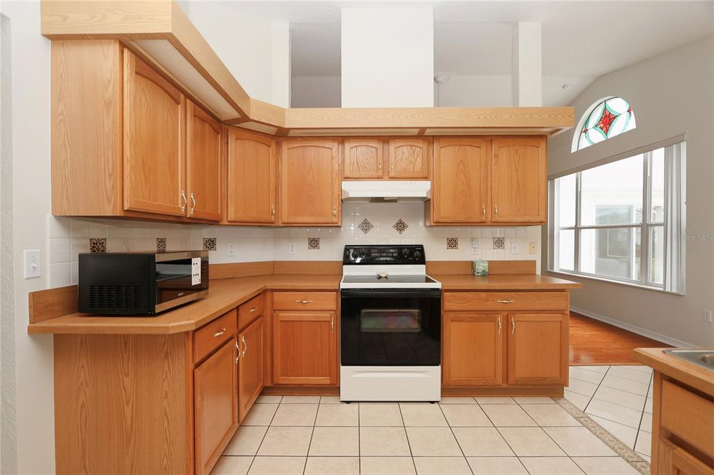 6318 Southwest 117th Loop Ocala, FL 34476 - Photo 20 of 60 a kitchen with stainless steel appliances granite countertop a stove a sink and a microwave