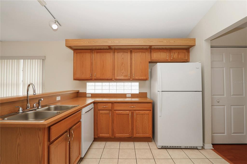 6318 Southwest 117th Loop Ocala, FL 34476 - Photo 21 of 60 a kitchen with a sink refrigerator and cabinets