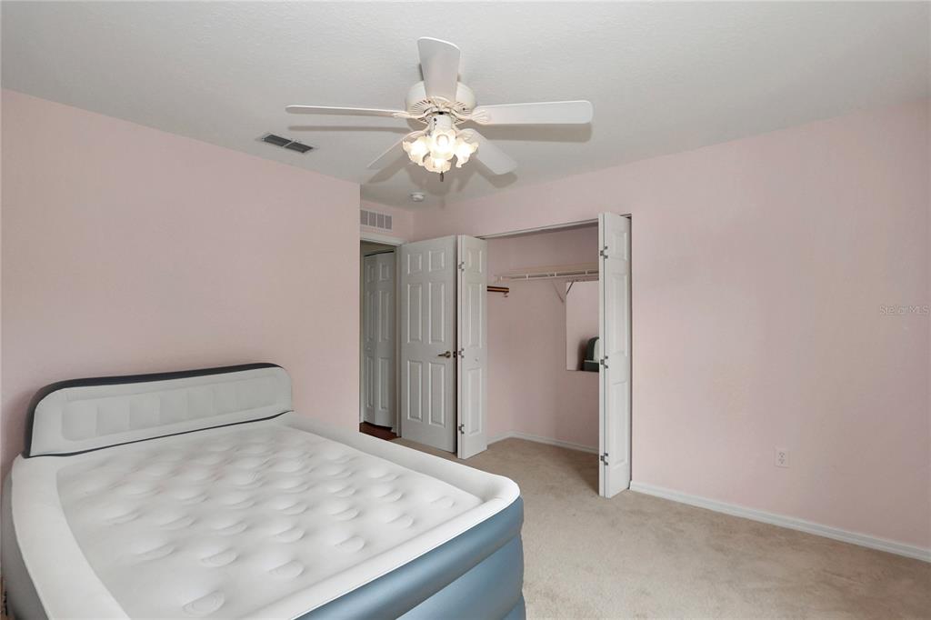 6318 Southwest 117th Loop Ocala, FL 34476 - Photo 27 of 60 a bedroom with a bed and a chandelier