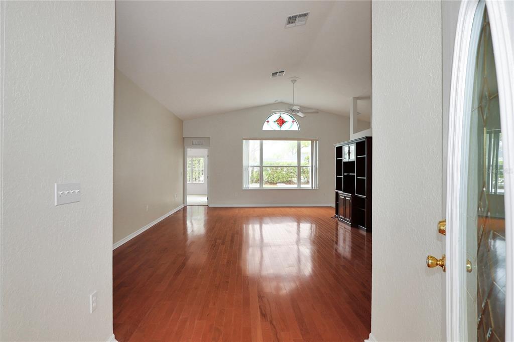 6318 Southwest 117th Loop Ocala, FL 34476 - Photo 4 of 60 an empty room with wooden floor and windows