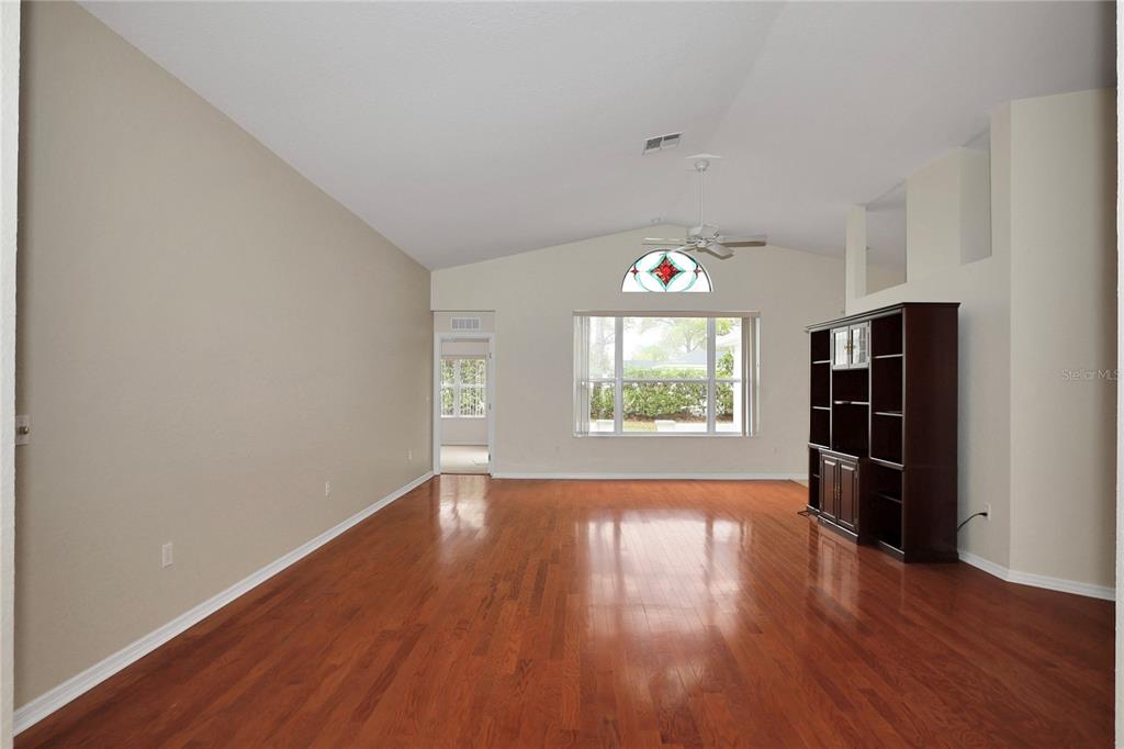 6318 Southwest 117th Loop Ocala, FL 34476 - Photo 6 of 60 wooden floor in an empty room with a window