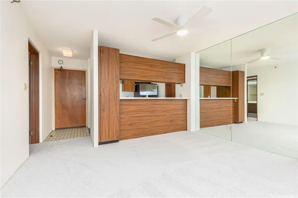a view of an empty room with closet and cabinet