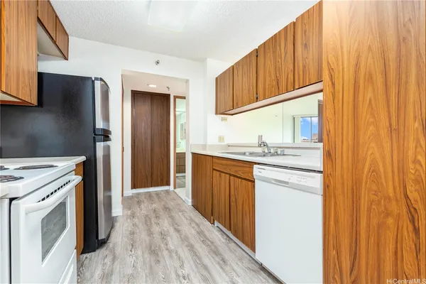 a kitchen with stainless steel appliances granite countertop a refrigerator a sink dishwasher and wooden cabinets with wooden floor