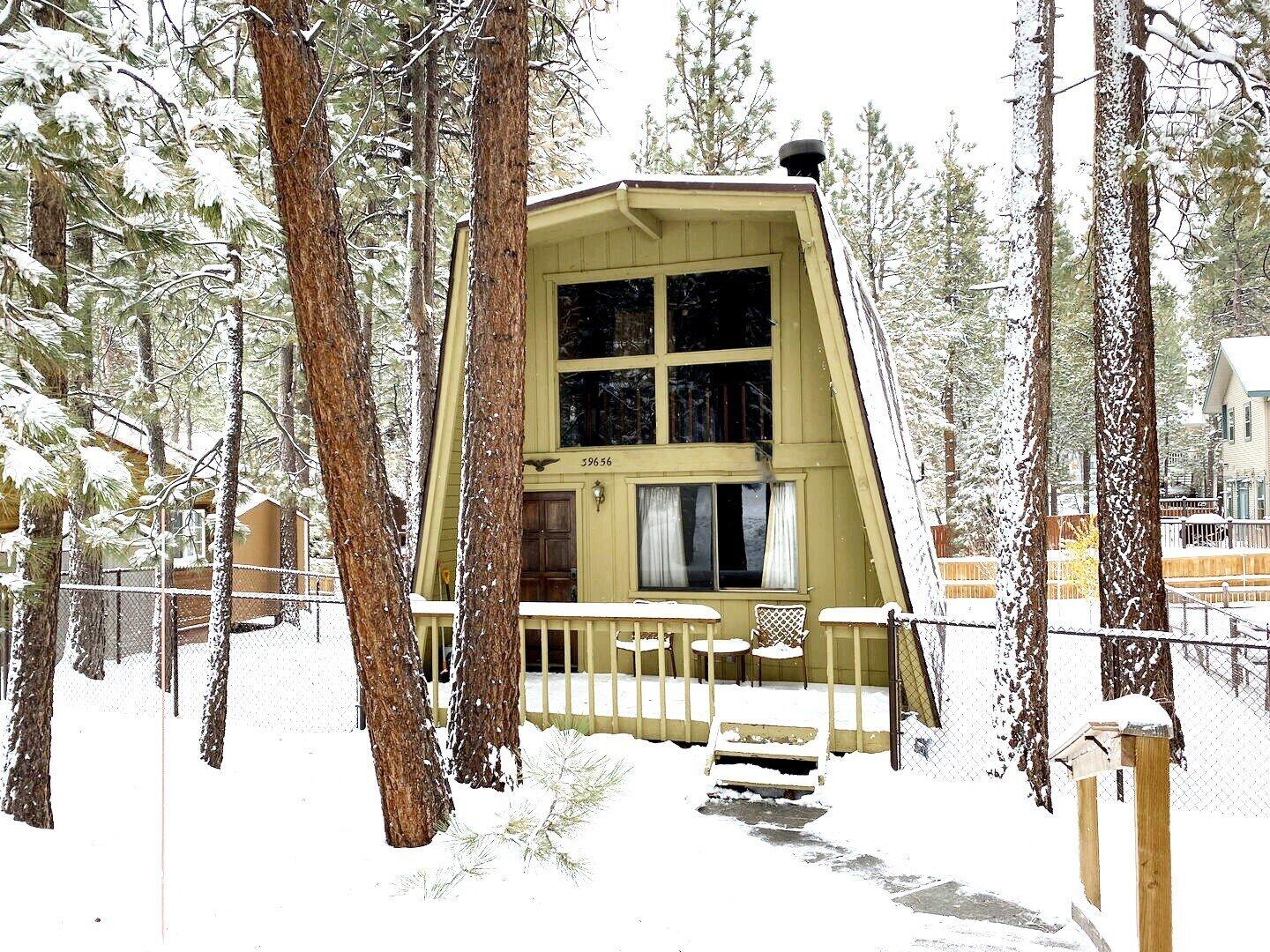 a front view of a house with a tree