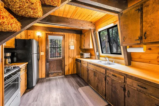 a kitchen with stainless steel appliances a stove a refrigerator and wooden floor