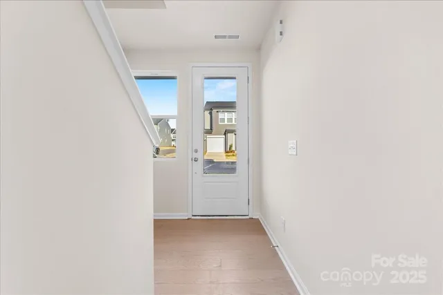 a view of a hallway with wooden floor and entryway