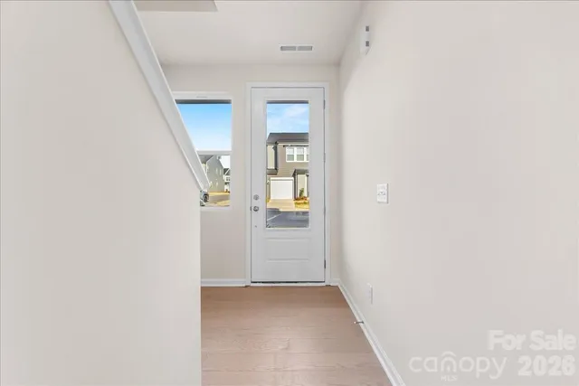 a view of a hallway with wooden floor and entryway