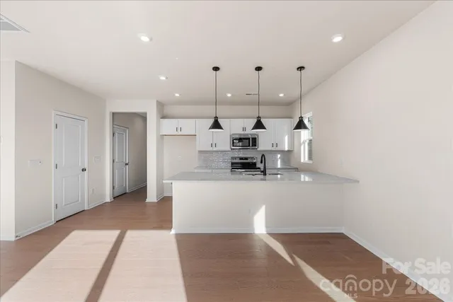 a view of a living room a kitchen and a chandelier