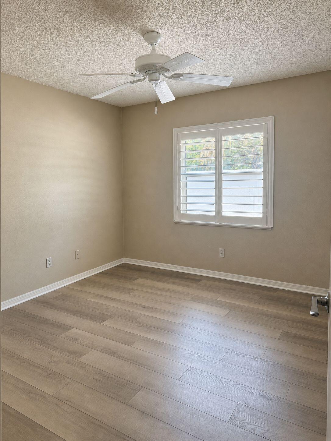 1871 Southwest Palm City Road, Unit G401 Stuart, FL 34994 - Photo 11 of 16 an empty room with wooden floor and windows