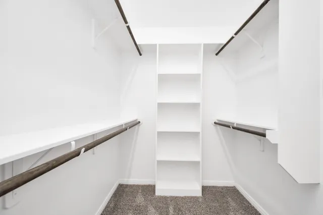 a view of walk in closet with empty racks