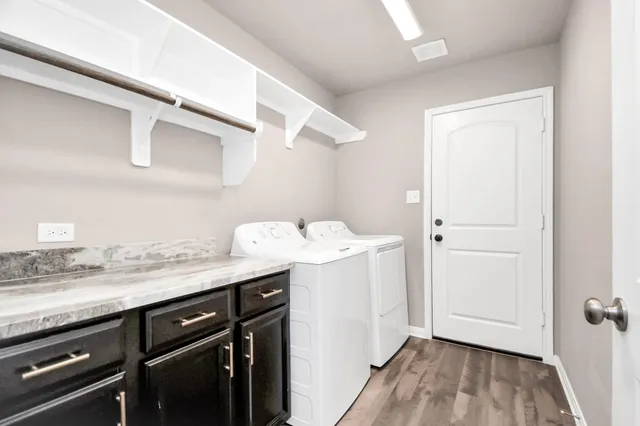 a utility room with cabinets washer and dryer