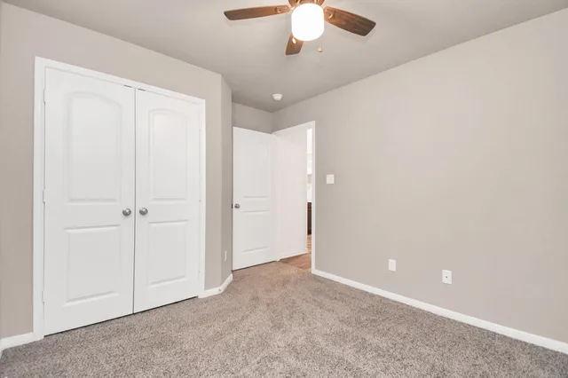 an empty room with chandelier fan