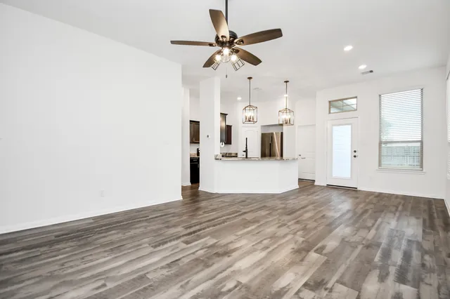 a view of a kitchen with wooden floor and a ceiling fan