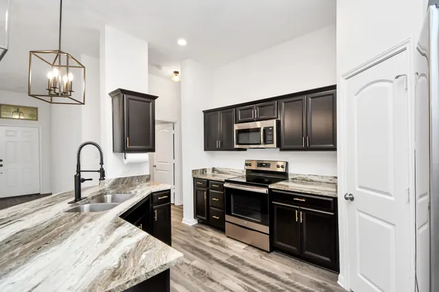 a kitchen with stainless steel appliances a stove microwave and refrigerator