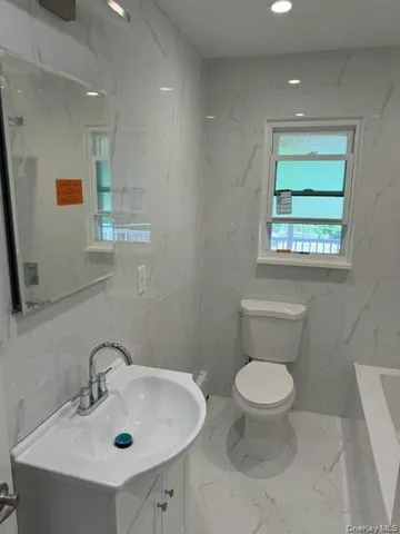a bathroom with a sink toilet and a mirror
