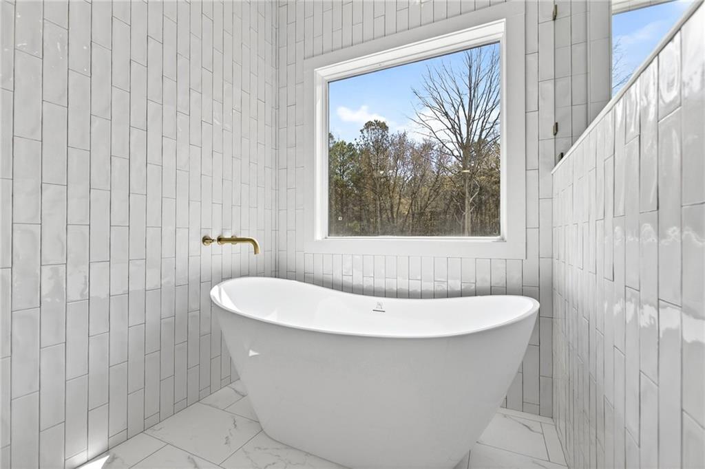 88 Carolyn Path Rockmart, GA 30153 - Photo 31 of 73 a white bath tub sitting in a bathroom next to a window