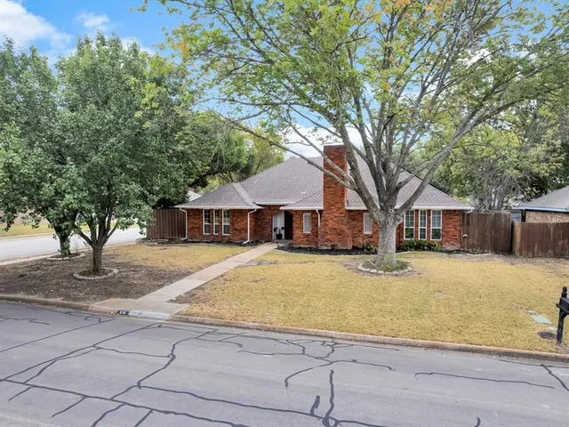a front view of a house with a yard and trees