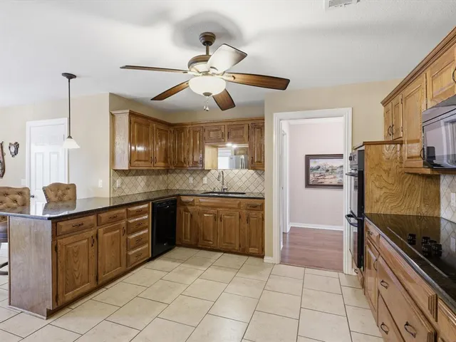 a kitchen with stainless steel appliances granite countertop a sink and a refrigerator