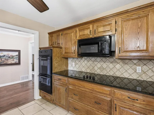 a kitchen with granite countertop cabinets stainless steel appliances and wooden floor
