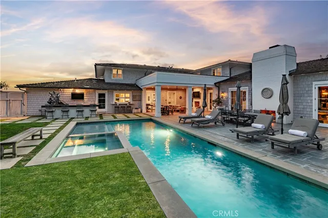 a view of a house with swimming pool and chairs