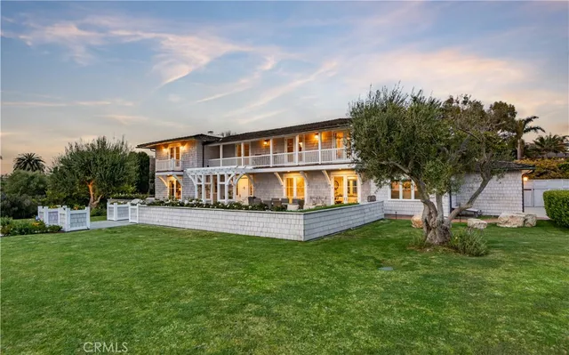 a view of a house with a big yard and large trees