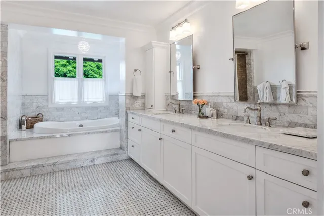 a bathroom with a granite countertop sink mirror and a bathtub
