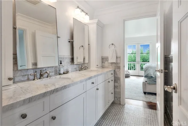 a en suite bathroom with a granite countertop double vanity sink a mirror and a shower